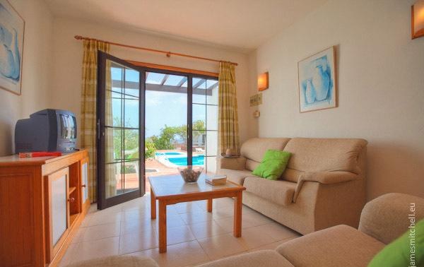 Salón de un bungalow con vistas a la piscina